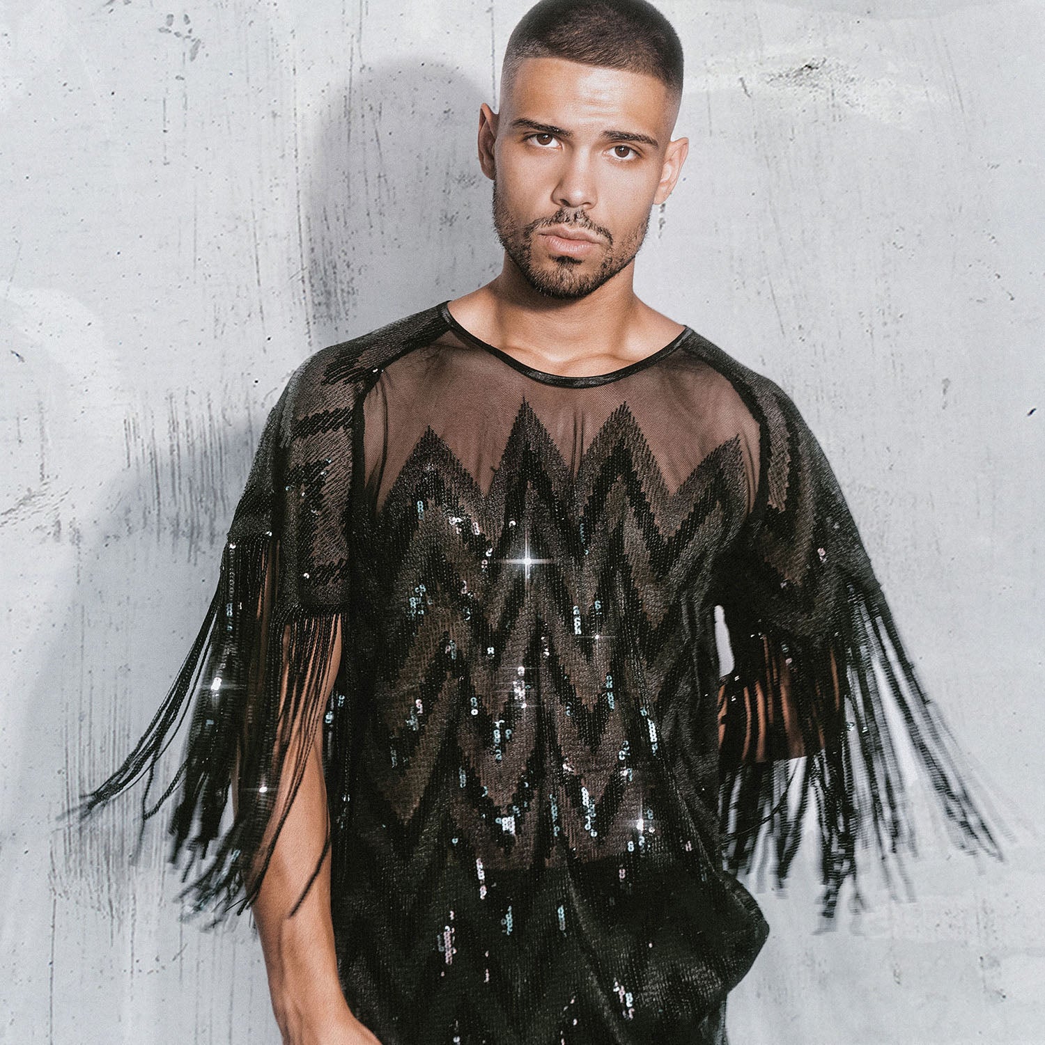 Male Model Posing on the white wall with Sequence Black Shirt with fringes  